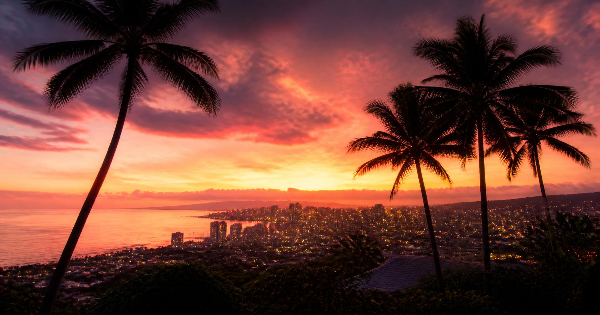 Warm sunset over Honolulu skyline with palm trees framing the Pacific Ocean